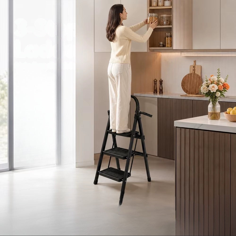 Femme debout sur l'escabeau 3 marches noir pour atteindre un placard haut de cuisine | Everclimb