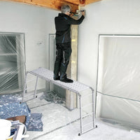 Artisan debout sur l'échelle multifonction aluminium en position échafaudage, plateaux installés, sur un chantier intérieur | Everclimb